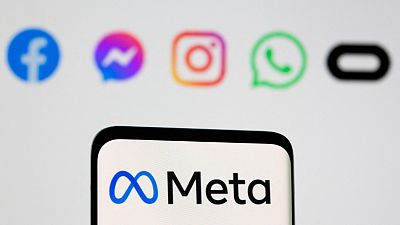 Facebook's rebrand logo Meta is seen on a smartphone in front of the logos of Facebook, Messenger, Intagram, WhatsApp, Oculus in this file photo taken October 28, 2021.