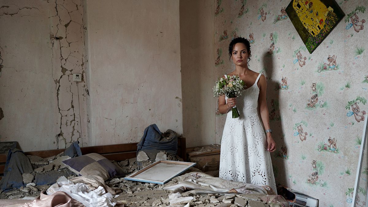 Daria Steniukova, 31, yoga coach poses for a picture during the wedding photo shooting in her bombed flat in Vinnytsya on July 16, 2022.