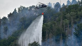 Erdőtüzet oltanak helikopterről a Ceské Svycarsko (Cseh Svájc) Nemzeti Parkban, Hrensko környékén 2022. július 27-én.