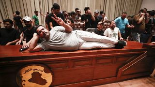 A supporter of the Iraqi cleric Moqtada Sadr, lies on the desk of the speaker of the Iraqi parliament.