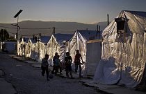 أطفال سوريون يلعبون كرة القدم بجوار خيامهم في مخيم للاجئين في بلدة بر الياس في سهل البقاع، لبنان، 7 يوليو / تموز 2022.