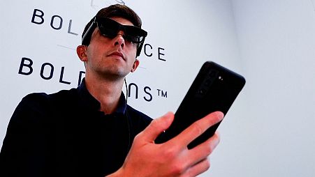 Image shows a hearing-impaired individual using new XRAI AR glasses.