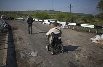 A disabled person goes over the bridge on a wheelchair at a pro-Russian insurgent checkpoint that has been used to block access to a road leading to Slovyansk, Ukraine.