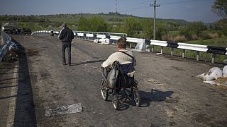 A disabled person goes over the bridge on a wheelchair at a pro-Russian insurgent checkpoint that has been used to block access to a road leading to Slovyansk, Ukraine. 