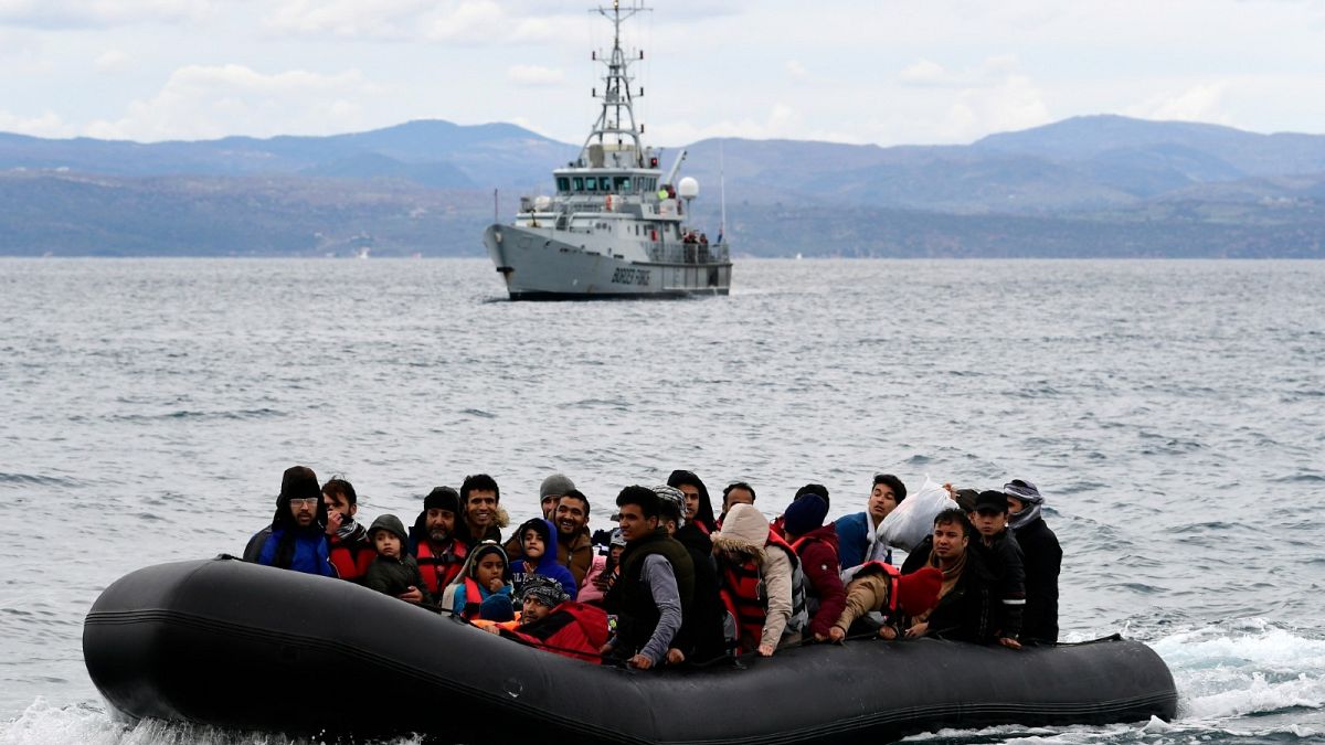 Migrants in a dinghy are accompanied by a Frontex vessel, on the Greek island of Lesbos, after crossing the Aegean sea from Turkey, Feb. 28, 2020.