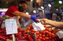 Un cliente paga verduras en el mercado Maravillas de Madrid, el 12 de mayo de 2022