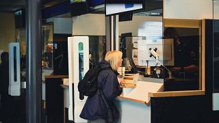 Des touristes russes font contrôler leur passeport le 28 juillet 2022 au poste frontière de Nuijamaa, en Finlande.