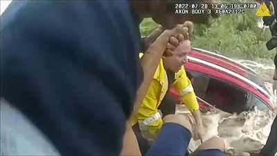 شرطي ينقذ امرأة من سيارتها الغارقة في الفيضانات بولاية أريزونا الأمريكية.