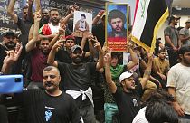Des partisans de Moqtada Sadr portent son portrait au sein du parlement irakian, Bagdad, le 30 juillet 2022