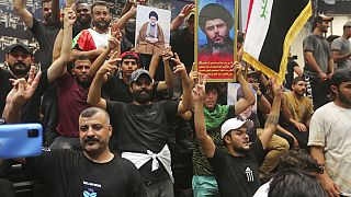 Des partisans de Moqtada Sadr portent son portrait au sein du parlement irakian, Bagdad, le 30 juillet 2022