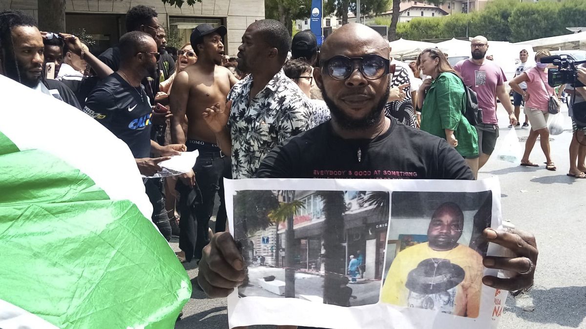 Un hombre muestra una foto de la víctima, el vendedor ambulante nigeriano Alika Ogorchukwu, en Civitanova Marche, Italia, el 30 de julio de 2022