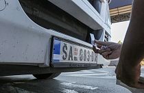 Serb truck driver Branko Todorovic places stickers on license car plates in Merdare border crossing on Monday, 4 October 2021.