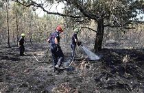 رجال الإطفاء يخمدون النيران في غابة محترقة في جنوب غرب فرنسا، الخميس 21 يوليو 2022.