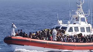 Una nave della Guardia Costiera con un gruppo di migranti nelle acque di Lampedusa