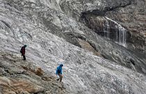 Hikers are seen walking next to the melting Fee Glacier above the Swiss alpine resort of Saas-Fee.