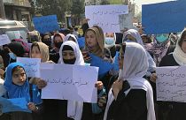 Mujeres afganas corean y sostienen carteles de protesta durante una manifestación en Kabul, Afganistán, el 26 de marzo de 2022.