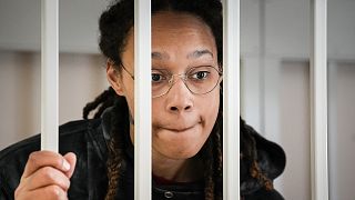 Brittney Griner speaks to her lawyers standing in a cage at a court room prior to a hearing, in Khimki just outside Moscow, 26 July 2022