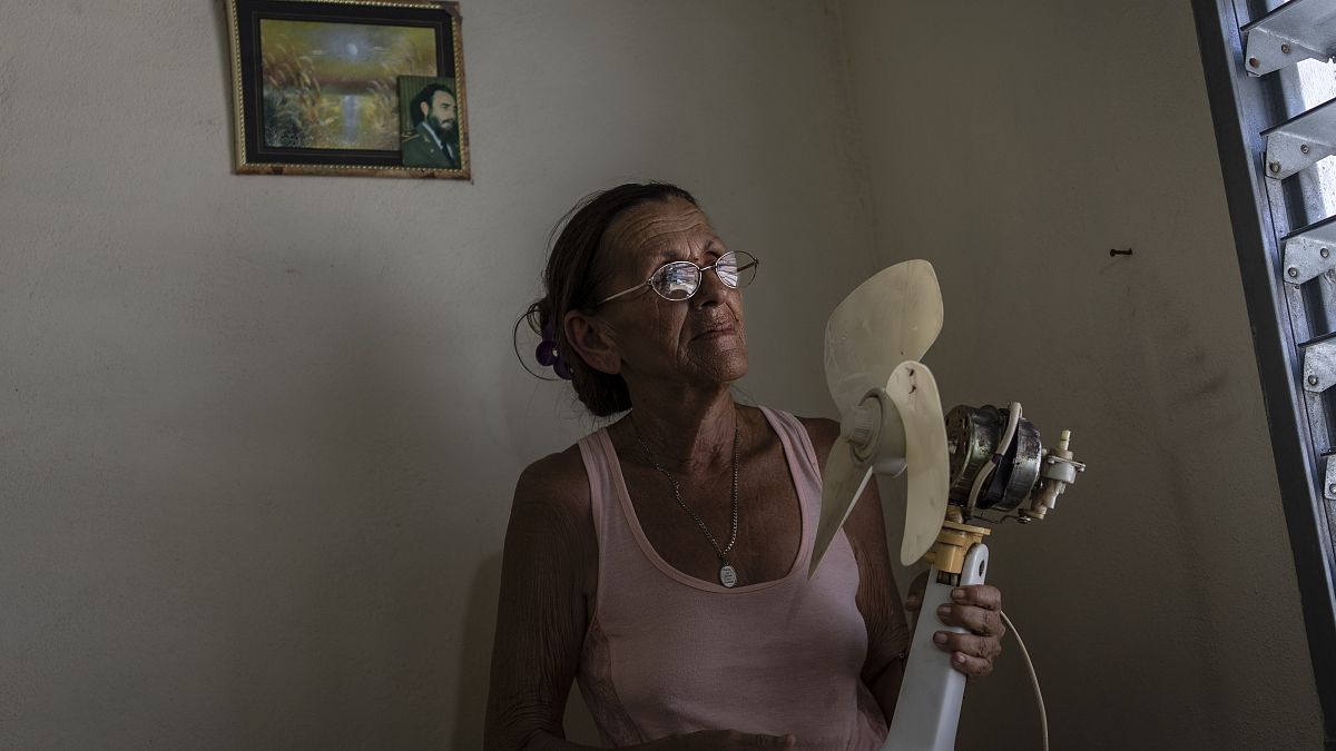 Miriam Cortés posa con su ventilador en Regla, Cuba, el lunes 1 de agosto de 2022. 
