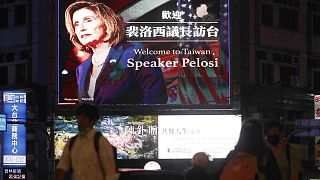 La gente pasa por delante de una valla publicitaria que da la bienvenida a la presidenta de la Cámara de Representantes de Estados Unidos, Nancy Pelosi, en Taipei, Taiwán,