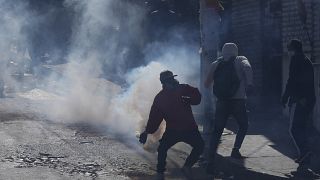 Un vendedor de coca devuelve un bote de gas lacrimógeno disparado por la policía antidisturbios durante el segundo día de protestas en La Paz
