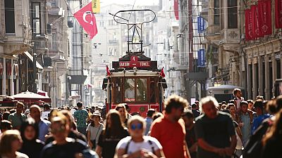 People walk in central Istanbul's Istiklal Avenue, the main shopping road of Istanbul, in this photo dated Wednesday, Aug. 22, 2018.