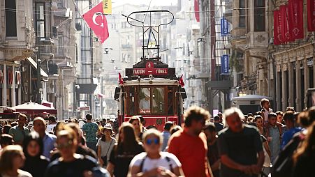 People walk in central Istanbul's Istiklal Avenue, the main shopping road of Istanbul, in this photo dated Wednesday, Aug. 22, 2018.