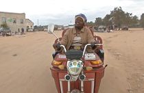 Danai Bvochora sur un tricycle électrique à Harare, au Zimbabwe