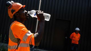 A worker drinks water in a construction site in Savenay, outside Nantes, on July 18, 2022, as a heatwave hits France.