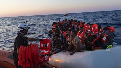 Seenotretter der "Sea-Watch 3" verteilen Rettungswesten an 108 Menschen in einem Boot in Seenot im zentralen Mittelmeer
