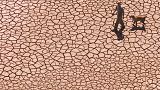 Imagen de archivo. Un hombre camina a través de un embalse seco y agrietado en el este de España
