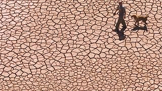 Imagen de archivo. Un hombre camina a través de un embalse seco y agrietado en el este de España