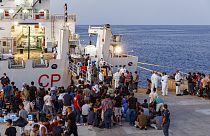 مهاجرون ينتظرون للصعود على متن سفينة تابعة لخفر السواحل الإيطالية في جزيرة لامبيدوزا الصقلية، إيطاليا، 3 أغسطس، 2022.