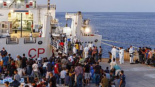 مهاجرون ينتظرون للصعود على متن سفينة تابعة لخفر السواحل الإيطالية في جزيرة لامبيدوزا الصقلية، إيطاليا، 3 أغسطس، 2022.
