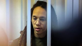 WNBA star and two-time Olympic gold medalist Brittney Griner stands behind bars in a courtroom for a hearing, in Khimki just outside Moscow, Russia, Tuesday, Aug. 2, 2022.