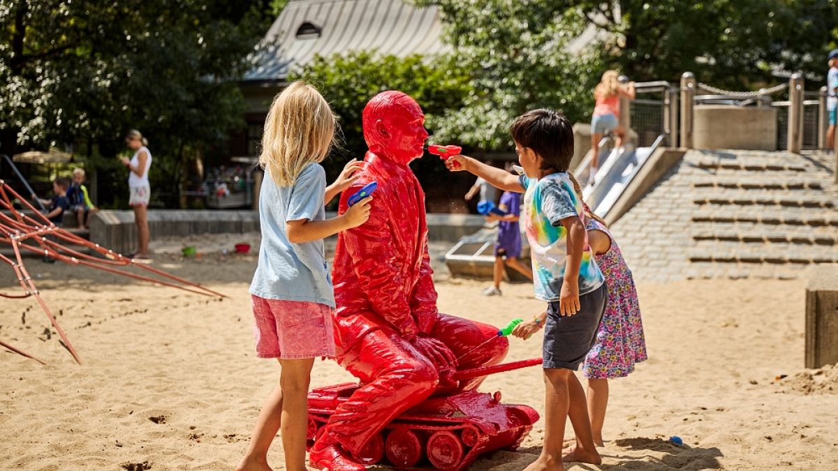 Children react to the work of James Colomina, installed in Central Park in New York, on August 3, 2022