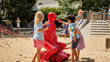 Children react to the work of James Colomina, installed in Central Park in New York, on August 3, 2022