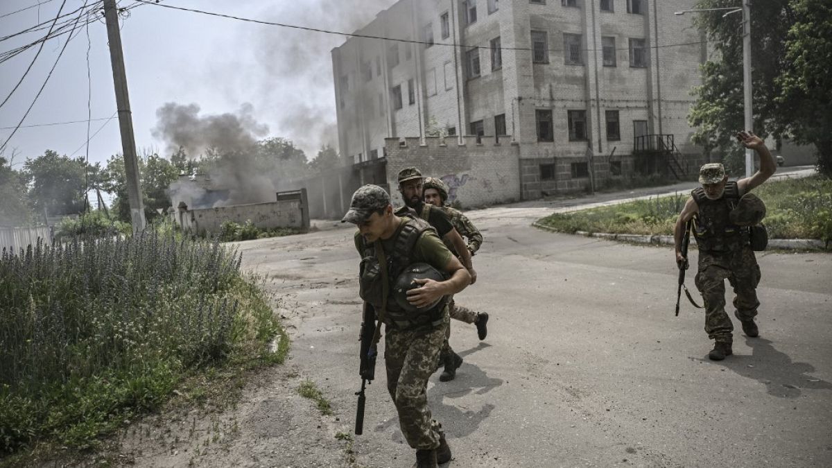 Ukrainian servicemen run for cover during an artillery duel between Ukrainian and Russian troops in the city of Lysychansk, eastern Ukrainian region of Donbas, in June, 2022.