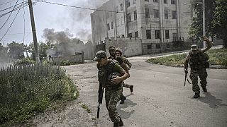 Ukrainian servicemen run for cover during an artillery duel between Ukrainian and Russian troops in the city of Lysychansk, eastern Ukrainian region of Donbas, in June, 2022.