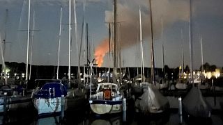 Smoke billows over sailing boats at a harbour of Berlin's suburb Spandau after explosions in a former munitions depot caused a wildfire at Grunewald Forest in Berlin, Germany