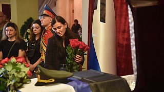 Elena Karabet, die Tochter von Olga Kachura steht am Sarg ihrer Mutter bei einer Trauerfeiern in Donezk am 4. August 2022.