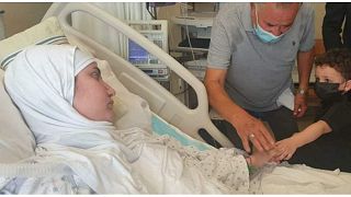 الطفل علي إلى جانب والدته ليليان شعيتو في المستشفى