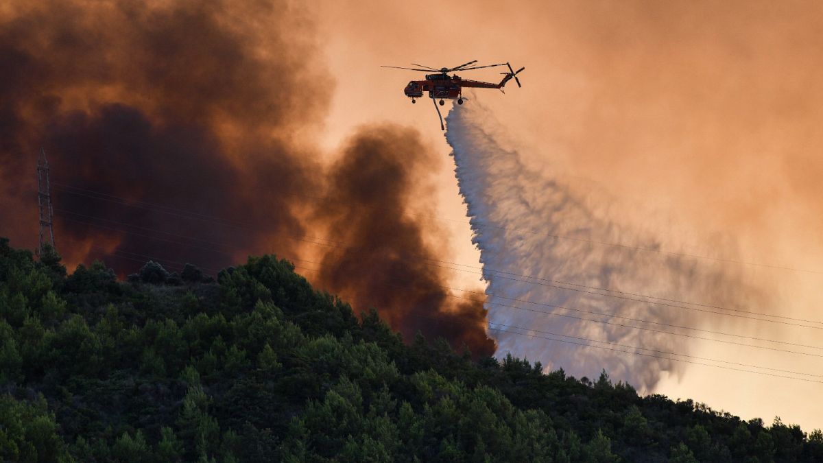 A firefighting helicopter throws water near the village of Krestena south of Ancient Olympia, southwest of Athens,  July 24, 2022. 