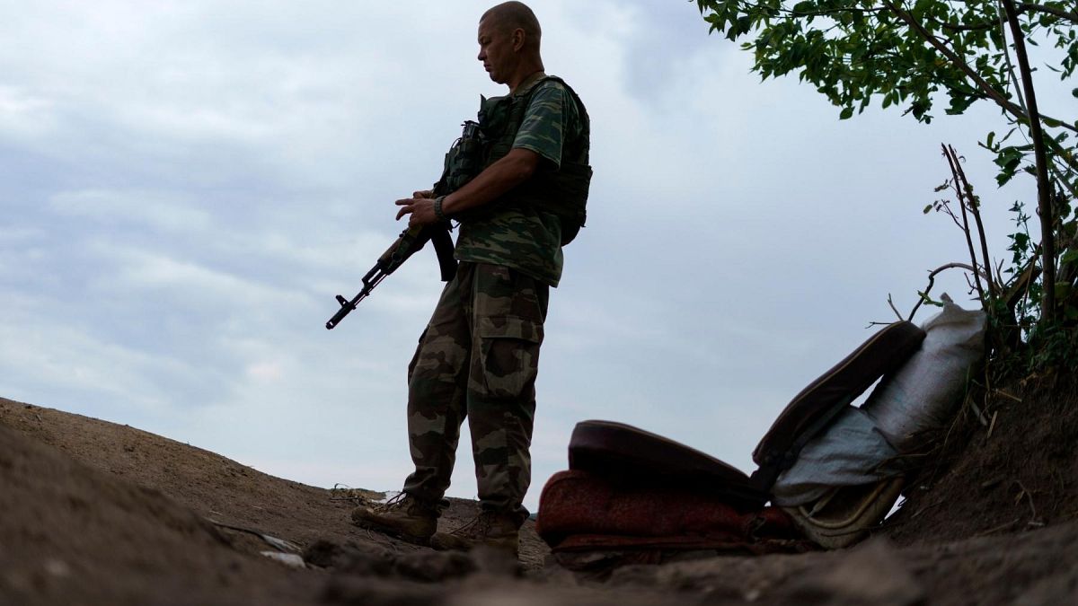 Ukrainian soldier Igor Ryazantsev with the Dnipro-1 regiment keeps watch outside his tent near Sloviansk, eastern Ukraine, 5 August 2022