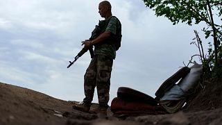Ukrainian soldier Igor Ryazantsev with the Dnipro-1 regiment keeps watch outside his tent near Sloviansk, eastern Ukraine, 5 August 2022