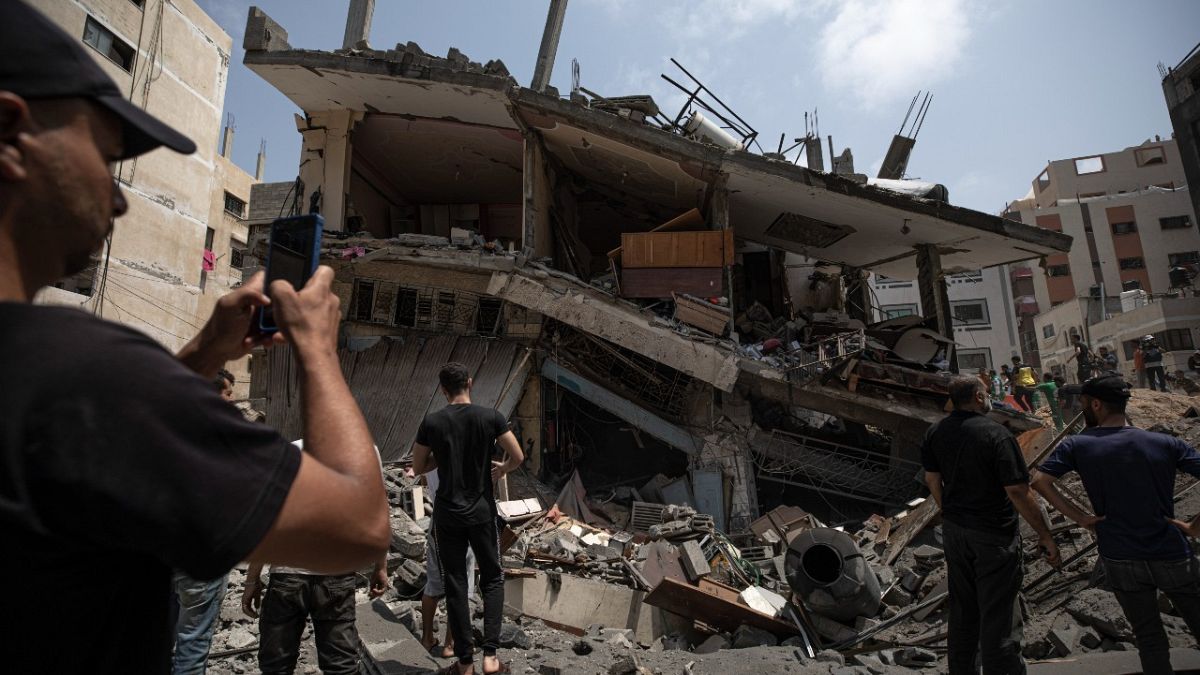 Palestinians inspect the damaged residential building after it was hit by Israeli airstrikes, in Gaza, Saturday, Aug. 6, 2022.