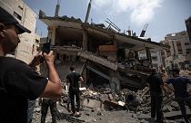 Palestinians inspect the damaged residential building after it was hit by Israeli airstrikes, in Gaza, Saturday, Aug. 6, 2022.