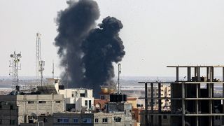 Smoke billows from a building struck during an Israeli air strike.
