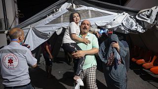 فلسطيني يحمل طفلة جريحة إلى مستشفى في رفح