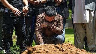 ألطاف حسين يبكي على قبر شقيقه أفتاب حسين في حديقة فيرفيو التذكارية في البوكيركي، نيو مكسيكو، يوم الجمعة 5 أغسطس 2022.