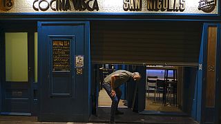 Un empleado cerrando un bar en Pamplona, en el norte de España
